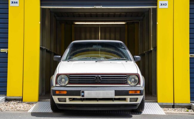White Volkswagen parked inside a yellow self-storage unit