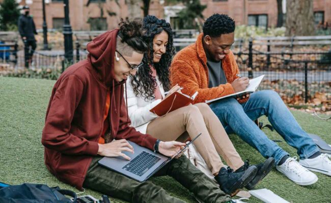 Group of diverse students studying together outside on campus
