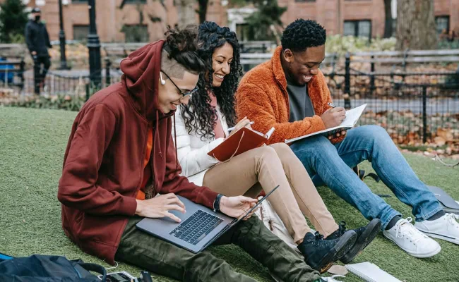 Group of diverse students studying together outside on campus