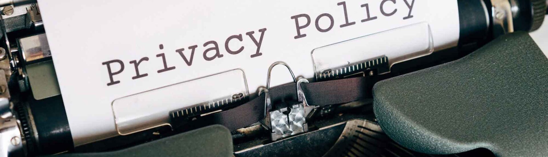 Close-up of a typewriter typing the words “Privacy Policy” on white paper