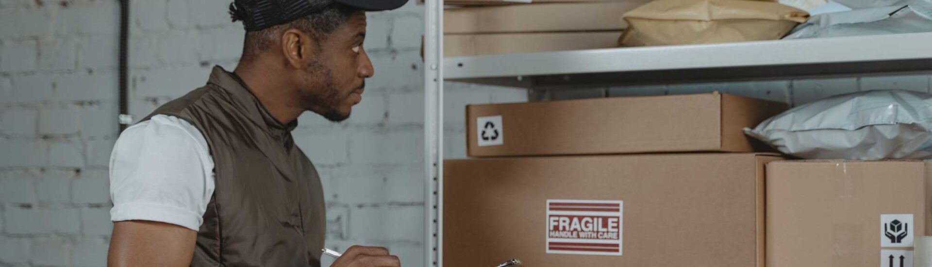 Warehouse worker checking inventory on shelves with labeled boxes